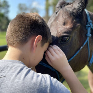 Young boy petting a horse