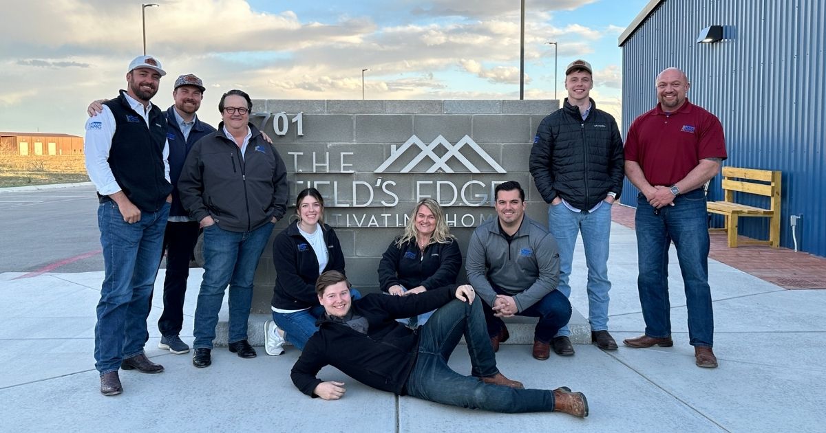 Group photo in front of The Field's Edge sign